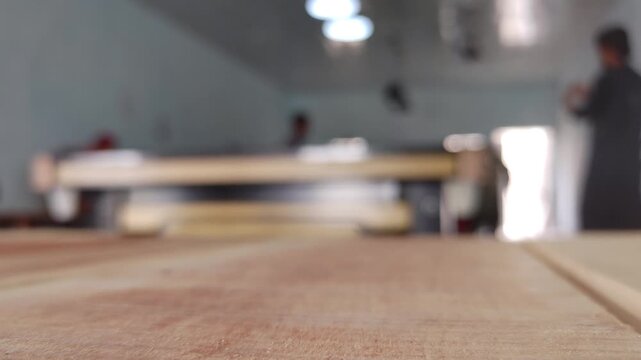 Empty wooden table in workshop. Blurred carpenter studio background. Industrial workspace concept.
