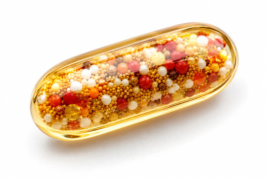 Transparent golden capsule filled with colorful microbeads isolated on white, representing dietary supplements, pharmaceuticals, nutrition, healthcare and advanced drug delivery