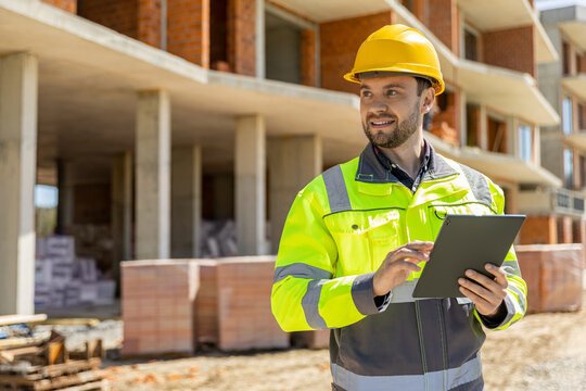 Cheerful building inspector holding mobile electronic pad device
