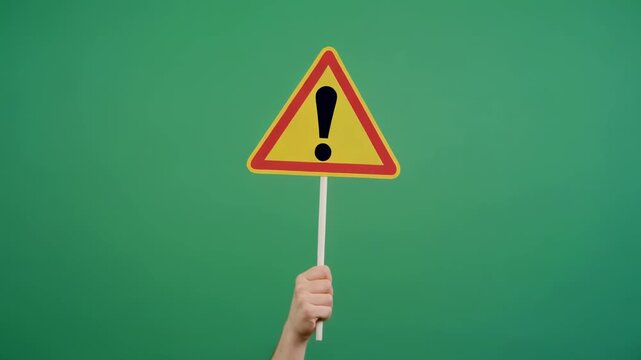 Caution sign displayed with cinematic motion against a green background symbolizing a warning concept