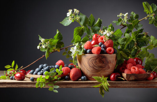 Berries closeup colorful assorted mix of strawberry, blueberry, raspberry and sweet cherry on a old wooden table.