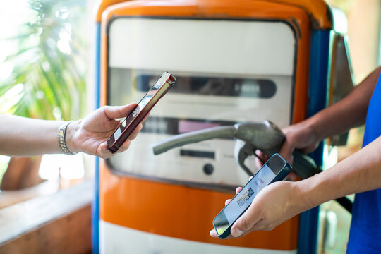 Selective focus to customer using smartphone for contactless mobile payment at a gas station pump