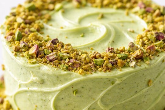 Pistachio Cake Topped with Crushed Nuts in Soft Lighting