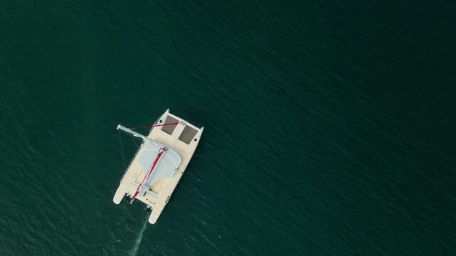 Aerial view of a white catamaran sailing on the dark green waters of the sea in Samana, Samana Province, Dominican Republic.