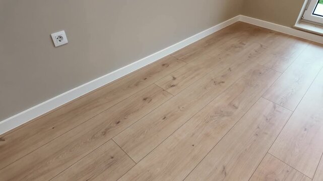 New laminate flooring. Empty room with floating laminate in new apartmen