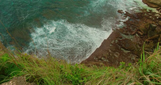 Clear turquoise ocean water flowing over rocky shore at Diamond Beach Nusa Penida Bali
