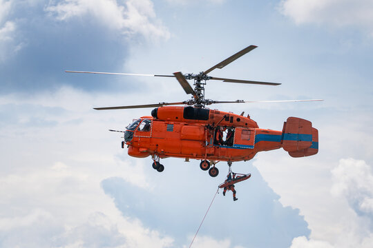 Helicopter Water Rescue Training with Rescuers Suspended on Hoist During Aerial Emergency Operation