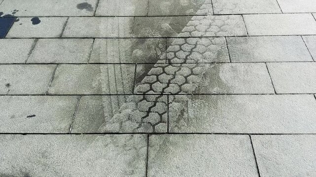 Wet Tire Track on Pavement as a Person Walks Past
