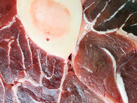 Fresh piece of beef shank with bone and marrow in the center. Culinary themes, osso buco recipes or stews. Macro. Close-up. Horizontal orientation. Raw meat