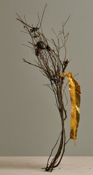 Gilded branches against a neutral backdrop, symbolizing nature's transformation