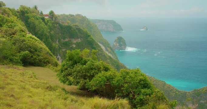 Scenic view of lush green ridges overlooking the turquoise Indian Ocean in Bali