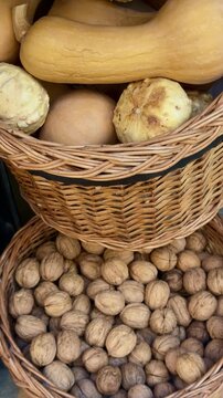 Wicker baskets filled with walnuts and rustic pumpkins at local farm market