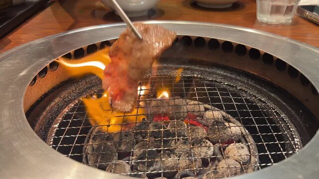 炭火焼肉、網の上で焼かれるお肉、炎が立つ焼肉シー