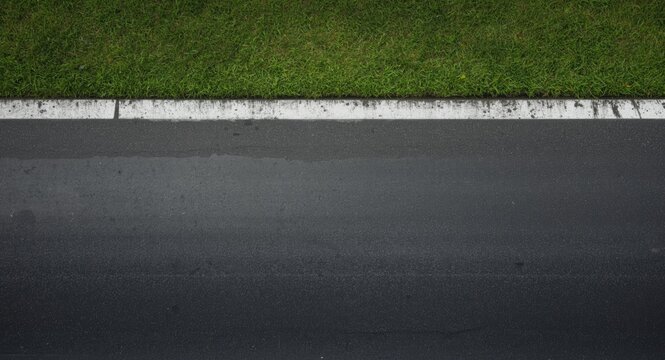 Grass Bordering a Wet Asphalt Road from Above in Natural Light