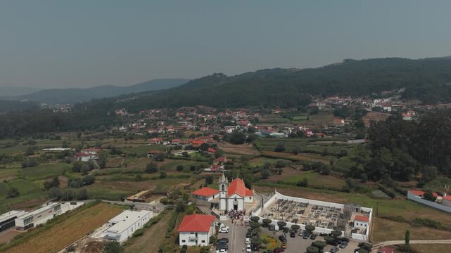Aerial view of Igreja Paroquial de Santo Andre de Palme with its cemetery and surrounding rural landscape in Palme, Braga, Portugal.