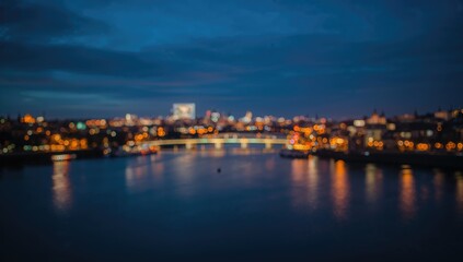 Fototapeta premium Blurred Cityscape Night View Over Water with Soft Lights