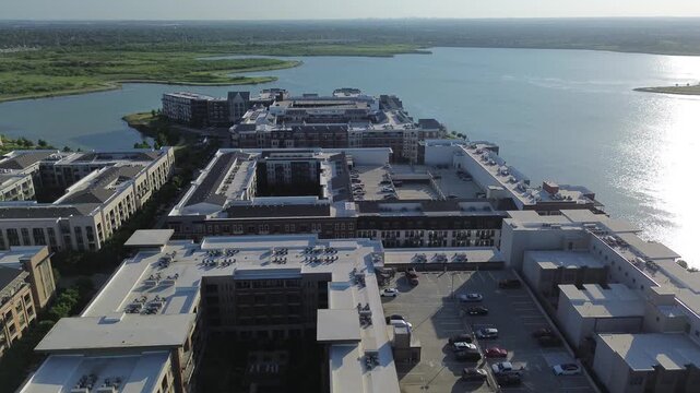 Multi tier residential structures face expansive North Lake waters across thriving Dallas suburbs. Courtyard apartment blocks frame open recreational waterfront districts, Coppell, Texas