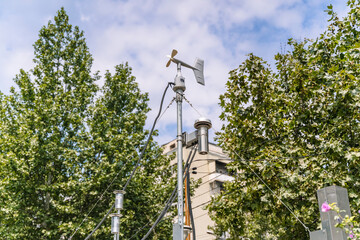 Weather station sensor mast with anemometer and meteorological equipment outdoors