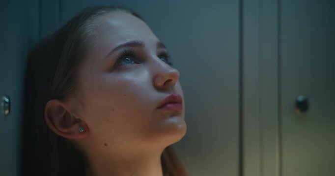 Close Up of Young Female Student Leaning Against School Lockers while Taking Quiet Moment Between Classes. Authentic Lifestyle Scene Reflection, Maturity, Inner Strength and Modern Teenage Life.