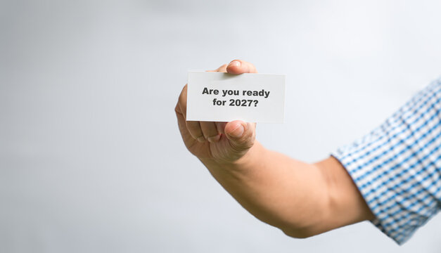 Man holding a white card with message - Are you ready for 2027. Close up view.