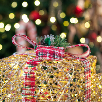 Christmas present tied with ribbon with bokeh lights in the background. Holiday concept.