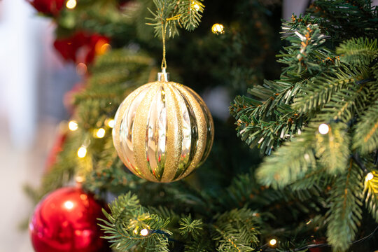 Golden ball ornament hanging on xmas tree. Christmas holiday concept.