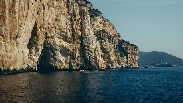 boat by the cliffs at sunset