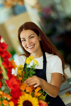 Smiling Florist Arranging Bright Bouquet in Local Flower Shop Promoting Small Business and Creativity