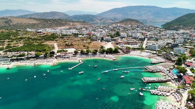 Aerial view of the best beach in Ksamil, hotels and beach bars, crystal clear sea, Ionian Sea, Saranda, Albania. Drone view from above. Sea and coast with sandy beach. Summer destination on the Medite