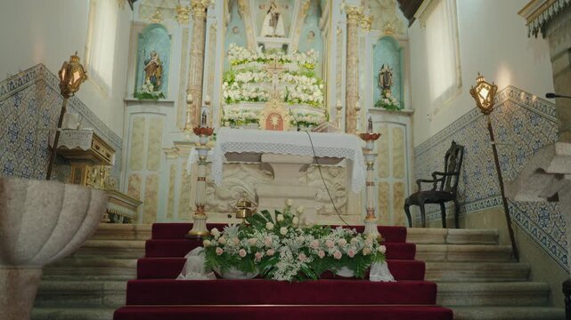 Baroque church altar with azulejo tiles white roses and a red carpet aisle set for a wedding