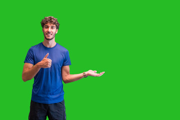 Fototapeta premium young man showing pointing gesture with gesture and expression. Isolated on green chroma background