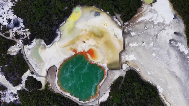Rotorua Champagne pool geothermal hot spring in Bay of Plenty, North Island, New Zealand, aerial drone of colorful thermal pool, volcanic landscape, steaming mineral formations and geothermal park.