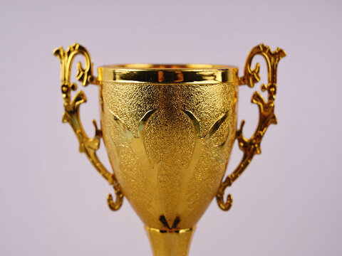 Elegant golden trophy cup isolated against a clean background, symbolizing achievement, competition, victory, success, and recognition.