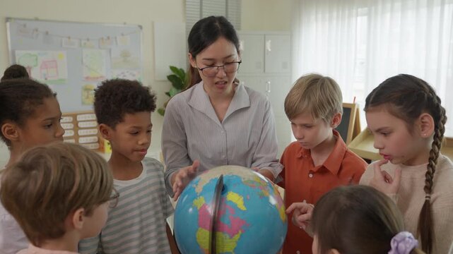 Teacher Guiding Diverse Children and Student Group With Colorful Globe During Classroom Geography Education Activity, Encouraging Curiosity, Teamwork, Cooperation, Learning, and Shared Discovery