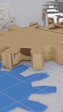 Close-up of cardboard gears on a blueprint grid, showing intricate design and construction