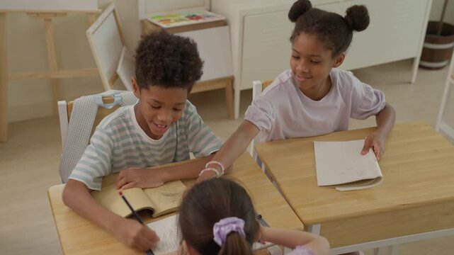 Children Studying Together Classroom, Diverse Elementary Student Collaboration, Sharing Workbook and Colored Pencils, Creative Education Learning Activity, Focused Drawing, Cooperation and Smiling