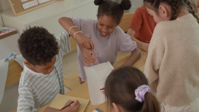 Children Drawing in Classroom with Teacher Guidance, Diverse Learners Creating Artwork Together, Inclusive Educational Activity Supporting Creative Learning, Teamwork, and Collaborative Expression