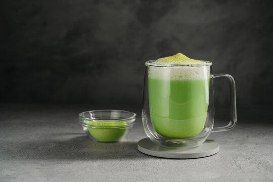 Matcha latte with green tea powder and frothy milk, matcha preparation and healthy beverage concept