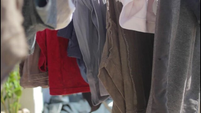 Indoor clothes rack holds wet garments during calm domestic afternoon. Soft clothes dry slowly inside cozy room creating peaceful vibe. Neat clothes concept shows practical home organization.
