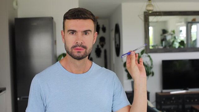 Man balancing pen on nose and laughing