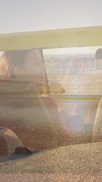 Animation of light over happy caucasian couple in car on beach