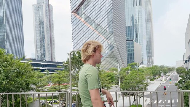 Young Man Using Smartphone Against Skyscrapers &ndash; Talking, Scrolling or Recording Video
