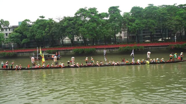 Group of people rowing together on a dragon boat in a river  