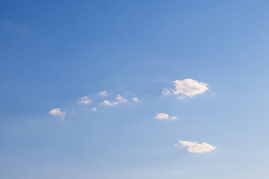 Clear blue sky with small scattered white clouds