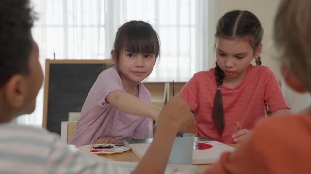 Children Sharing Food at Classroom Table, Friendship and Cooperation During Lunch Activity, Diverse Classmates Playing Games and Painting Colorful Artwork Together in Creative Learning Environment