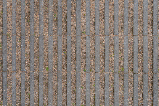 Permeable eco paving with concrete slabs and gravel joints, sustainable urban drainage surface top view texture