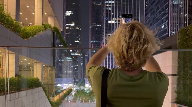 Young Man Using Smartphone Against Skyscrapers &ndash; Talking, Scrolling or Recording Video
