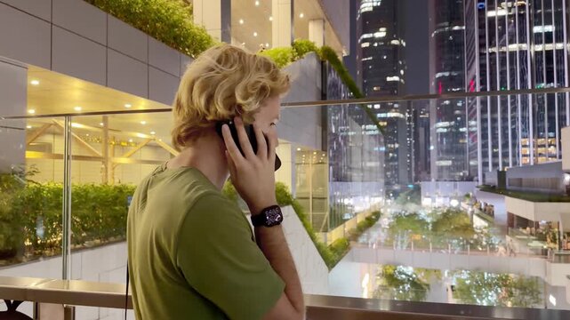 Young Man Using Smartphone Against Skyscrapers &ndash; Talking, Scrolling or Recording Video