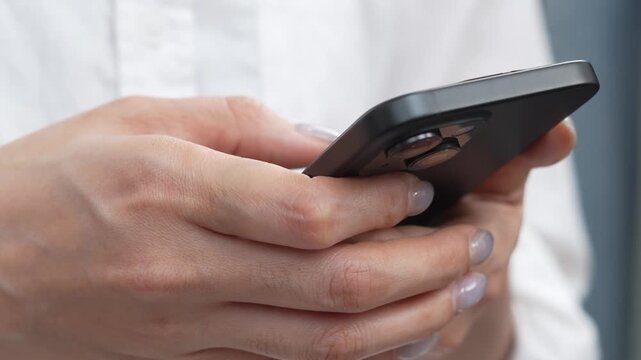 woman holds smart phone in her hands and scrolls through the news feed. Close up of hand uses mobile. point finger on screen, texting text message.	