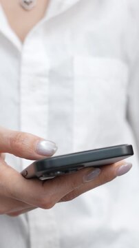 woman holds smart phone in her hands and scrolls through the news feed. Close up of hand uses mobile. point finger on screen, texting text message.	